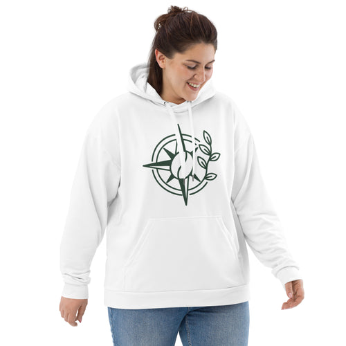 A woman wearing a white pullover hoodie with a dark green compass rose graphic on the chest, paired with blue jeans, set against a plain white background.