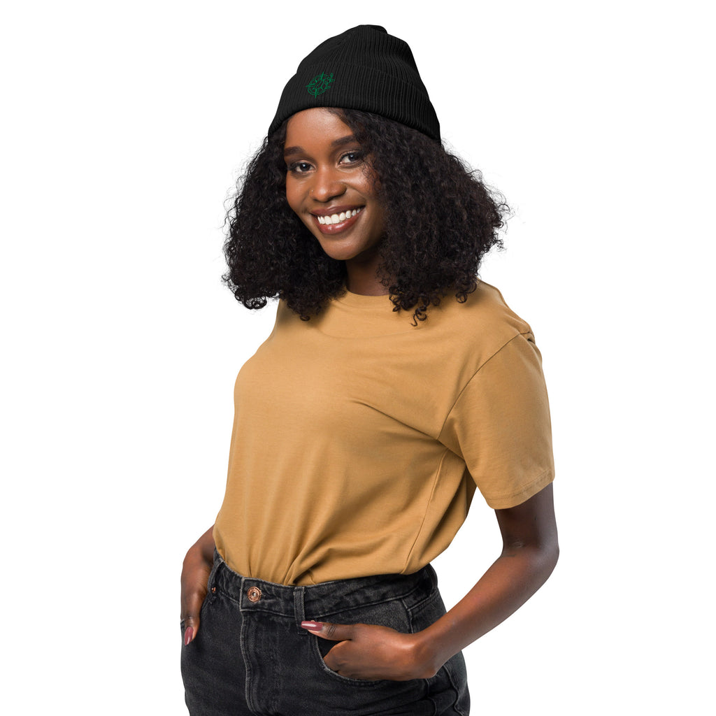 Woman wearing a mustard yellow shirt and black beanie on a white background