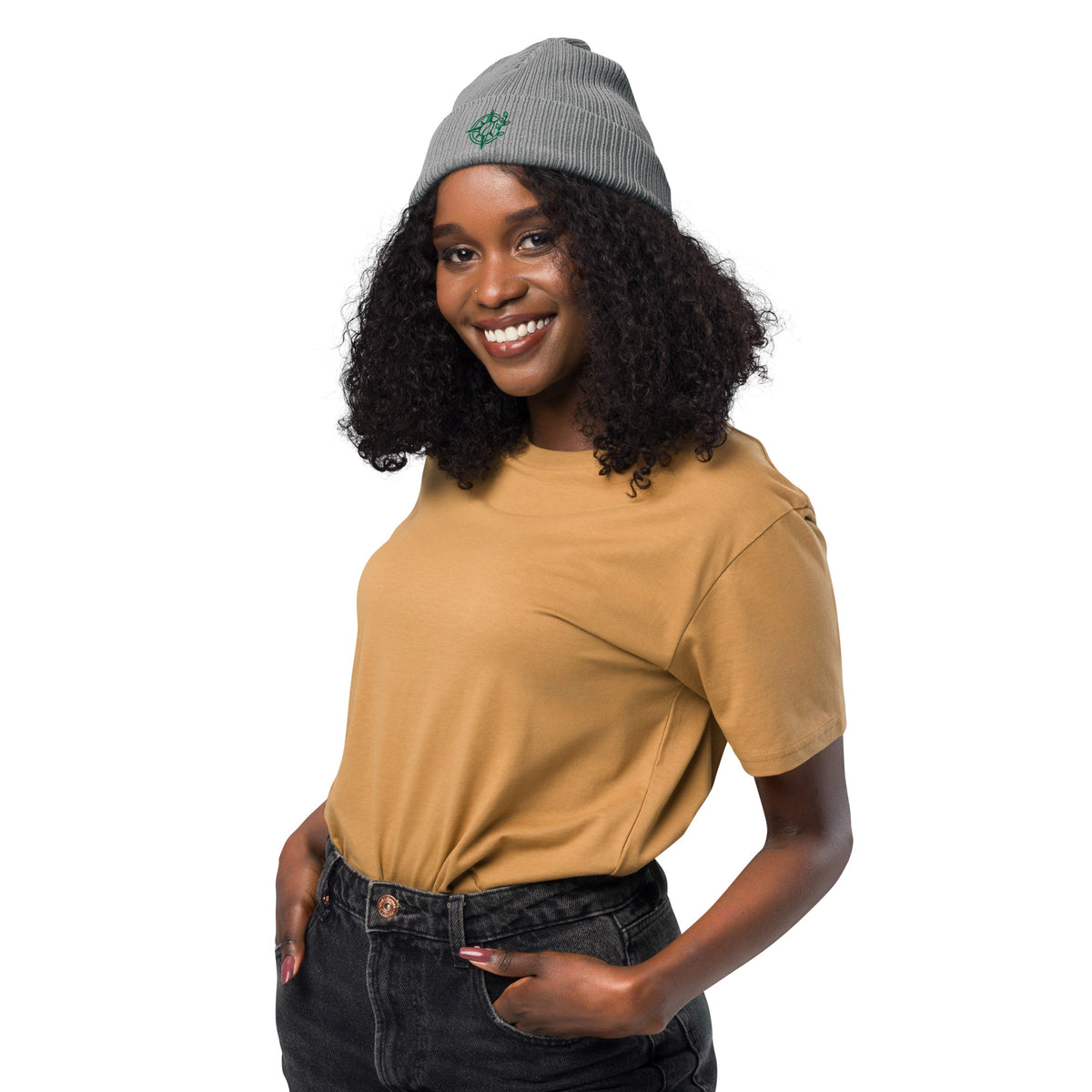 Woman wearing a mustard yellow shirt and gray beanie on a white background