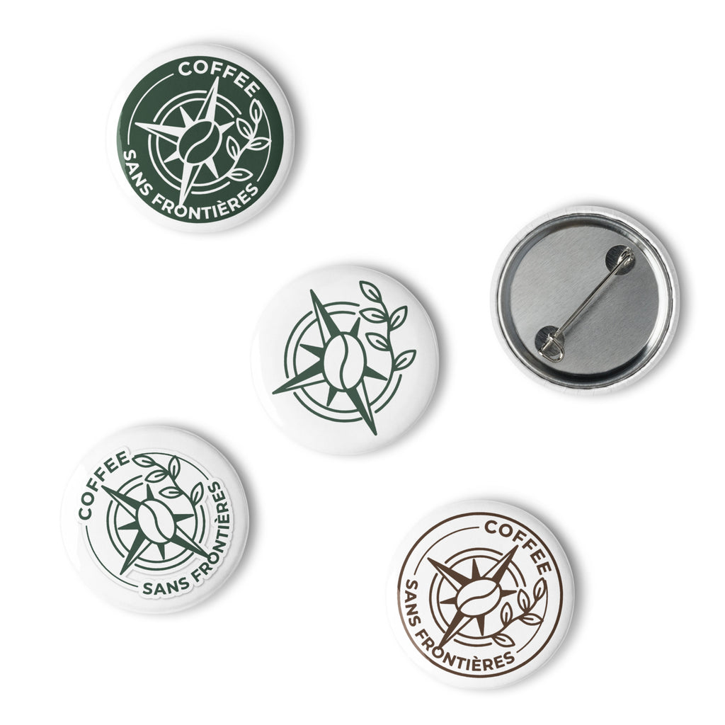 Five round pin-back buttons featuring the Coffee Sans Frontières logo in green and white, with one button showing the silver metal pin-back backing, on a plain white background.