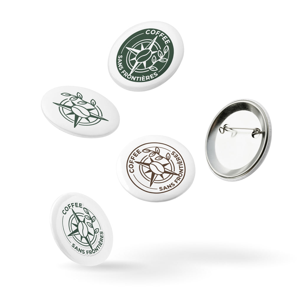 Five round pin-back buttons with the Coffee Sans Frontières logo, shown in white, green, and brown designs, with one button displaying its metal pin-back backing, on a white background.
